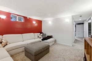 Carpeted living room featuring a textured ceiling