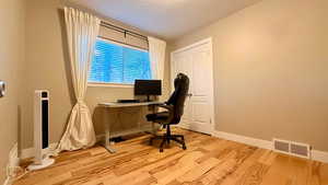 Office/ Bedroom area featuring light wood-style floors and a textured ceiling