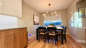 Dining space featuring light wood-style flooring and a chandelier