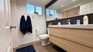 Bathroom featuring tile walls, vanity, and tile patterned floors