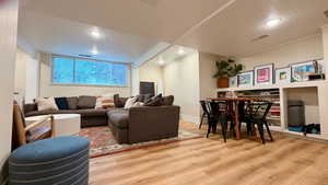 Living area featuring light wood-style flooring and a textured ceiling