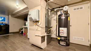 Utility room featuring heating unit and water heater