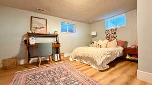 Bedroom featuring light wood finished floors and a textured ceiling