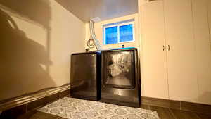 Laundry area featuring wood tiled floors and washer and clothes dryer
