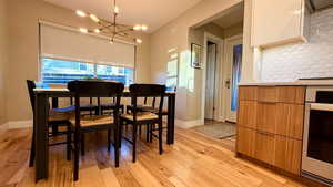 Dining area featuring light wood-style flooring and a chandelier