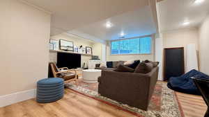 Living area featuring light wood finished floors, recessed lighting, and crown molding