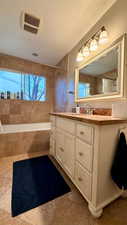 Full bathroom with vanity and a textured ceiling