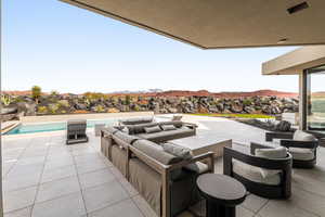 View of patio / terrace featuring outdoor furniture, an outdoor pool, and a mountain view