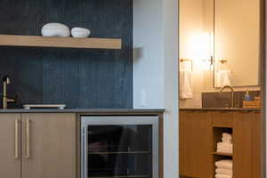 Indoor wet bar featuring beverage cooler, open shelves, and wood finish cabinets