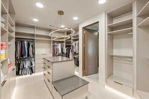 Walk in closet featuring light colored carpet