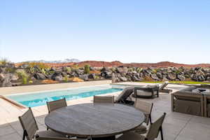 Outdoor pool with outdoor lounge area, a mountain view, and a patio area