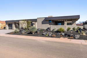Modern home featuring stucco siding, driveway, and an attached garage