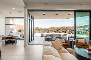 Living room featuring a mountain view, floor to ceiling windows, light tile patterned floors, and recessed lighting