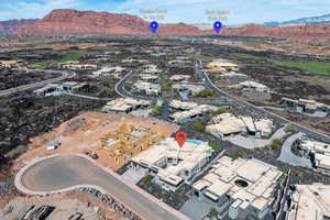 Aerial view of property and surrounding area featuring a mountain backdrop