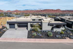 View of front of property featuring a patio area, an attached garage, a mountain view, driveway, and a residential view