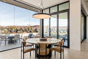 Dining area featuring expansive windows, a mountain view, light tile patterned flooring, and recessed lighting