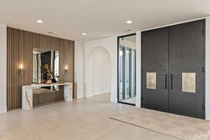 Foyer with arched walkways, recessed lighting, and expansive windows