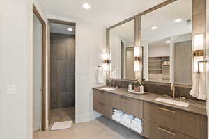Bathroom featuring double vanity, a spacious closet, light tile patterned flooring, recessed lighting, and decorative backsplash