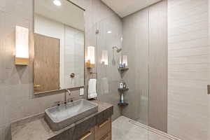Bathroom featuring vanity, walk in shower, and recessed lighting