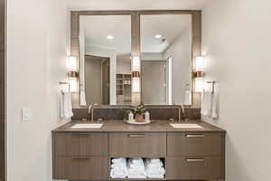 Bathroom with double vanity, backsplash, and recessed lighting