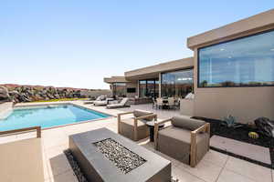 Swimming pool with a fire pit and outdoor lounge area