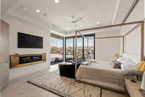 Bedroom with access to outside, a glass covered fireplace, light tile patterned floors, recessed lighting, and ceiling fan