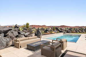 Swimming pool featuring a patio and an outdoor living space with a fire pit