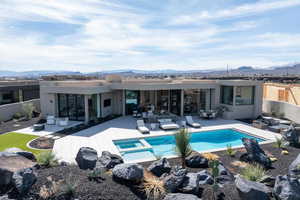 Rear view of house with a patio, a mountain view, outdoor furniture, and stucco siding