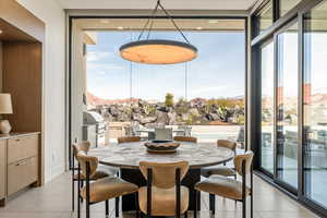 Dining space with floor to ceiling windows and light tile patterned flooring