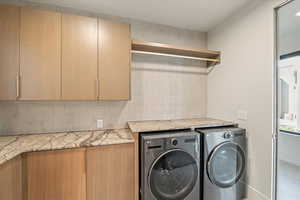 Laundry area with washer and clothes dryer and cabinet space