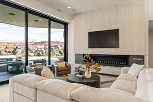 Living room featuring a high end fireplace, floor to ceiling windows, and recessed lighting