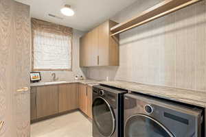 Laundry area with washer and clothes dryer and cabinet space