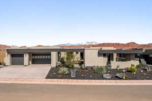 View of front of home featuring stucco siding, a mountain view, driveway, and an attached garage
