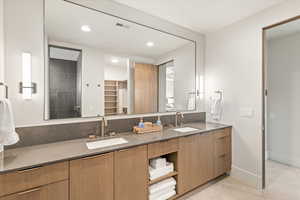 Full bath with double vanity, light tile patterned floors, a spacious closet, and recessed lighting