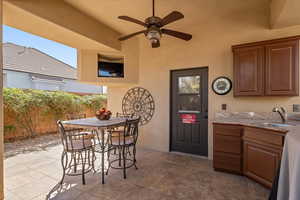 Kitchen with light countertops, a ceiling fan, and wood finish cabinetry