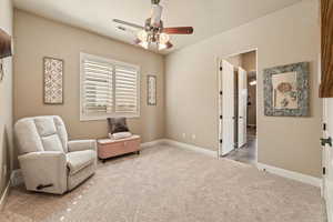 Living area with a ceiling fan and light colored carpet