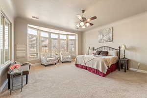 Bedroom with ceiling fan and light colored carpet
