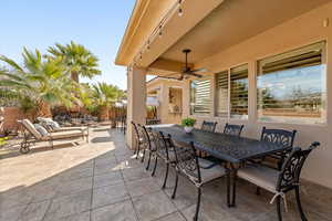 Fenced backyard featuring outdoor dining space, a patio, and a ceiling fan