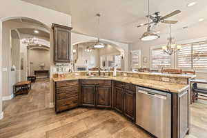 Kitchen with a ceiling fan, dark wood finish cabinets, and suspended lighting