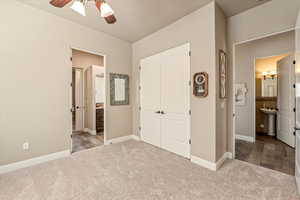 Unfurnished bedroom with connected bathroom, light carpet, and a closet