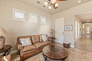 Living area with healthy amount of natural light, arched walkways, and a ceiling fan
