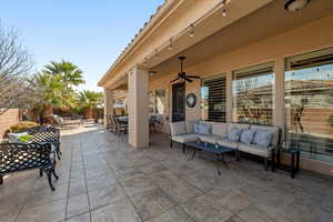 Fenced backyard featuring an outdoor hangout area, a patio area, and ceiling fan
