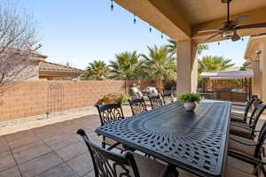 Fenced backyard with a patio area, ceiling fan, and an outdoor living / dining area