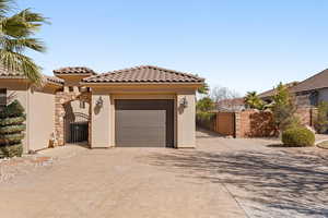 View of front of property with a gate, concrete driveway, stucco siding, and a tile roof