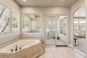 Ensuite bathroom with a whirlpool tub, healthy amount of natural light, inlaid floor details, a stall shower, and recessed lighting