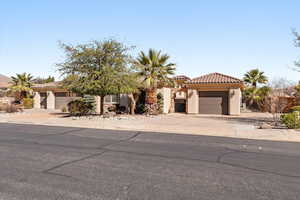 Mediterranean / spanish house featuring a tiled roof, stucco siding, an attached garage, and concrete driveway