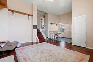 Entrance foyer featuring a ceiling fan, dark wood-style flooring, and a high ceiling