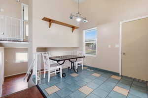 Dining area featuring a high ceiling, plenty of natural light, and light tile patterned floors