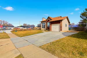 View of front of property featuring driveway, a garage, RV parking, and a chimney