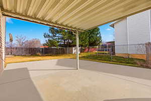 Fenced backyard with a covered patio area